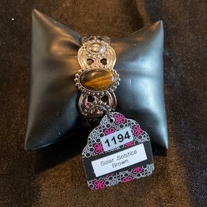 Silver cuff bracelet with tiger’s eye stone.